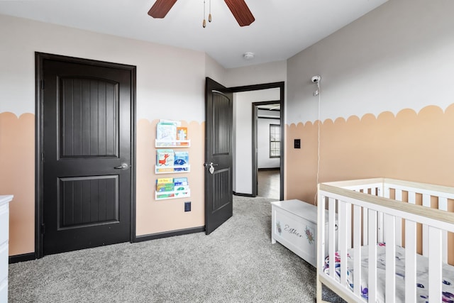 carpeted bedroom featuring a crib and ceiling fan