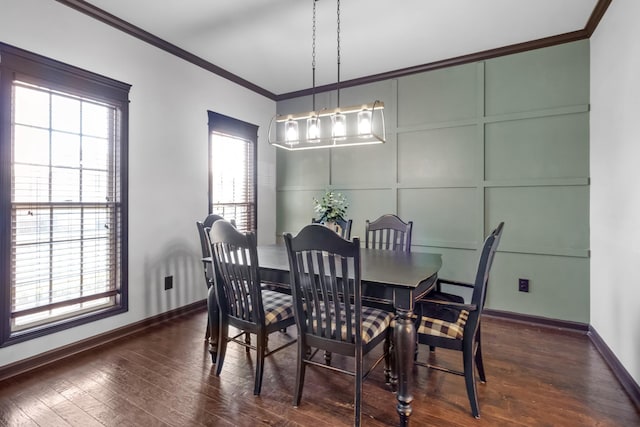 dining room with dark hardwood / wood-style floors, ornamental molding, and a notable chandelier