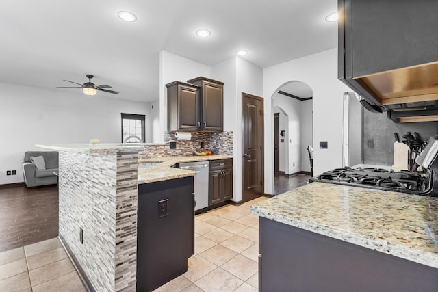 kitchen with kitchen peninsula, ceiling fan, light tile patterned flooring, and stainless steel dishwasher