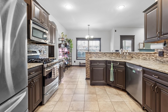 kitchen featuring sink, hanging light fixtures, dark brown cabinets, and appliances with stainless steel finishes