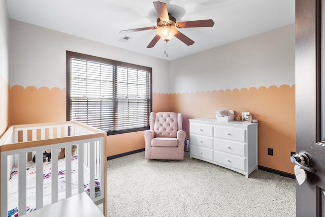 bedroom featuring ceiling fan and a crib