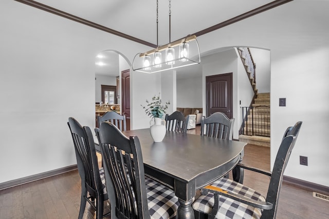 dining area featuring dark hardwood / wood-style floors and ornamental molding