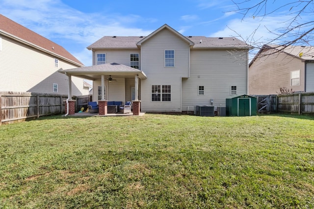 rear view of house with a lawn, an outdoor hangout area, ceiling fan, a shed, and a patio area