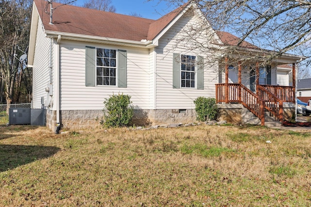 view of front of home featuring cooling unit and a front yard