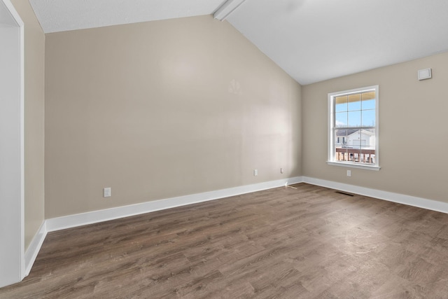 unfurnished room with dark wood-type flooring and lofted ceiling with beams