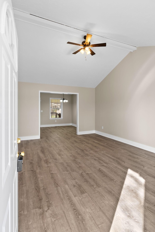 unfurnished living room with ceiling fan with notable chandelier, hardwood / wood-style floors, and vaulted ceiling with beams