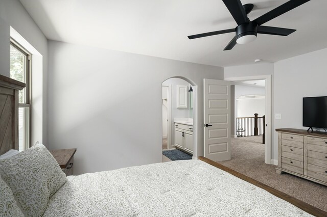 bedroom with connected bathroom, ceiling fan, and dark carpet