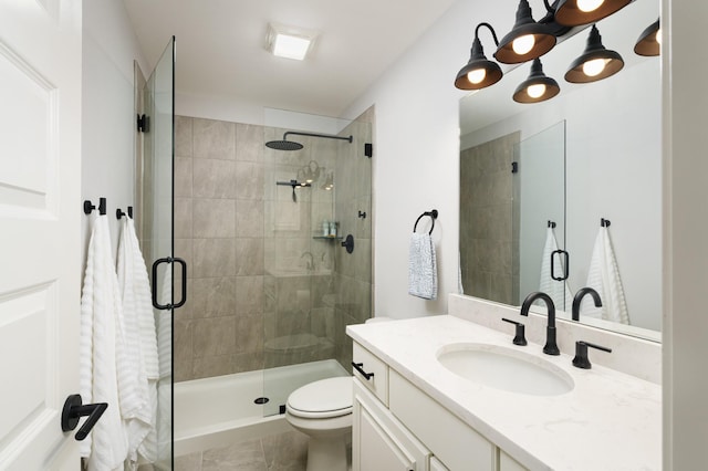 bathroom featuring tile patterned floors, vanity, toilet, and walk in shower