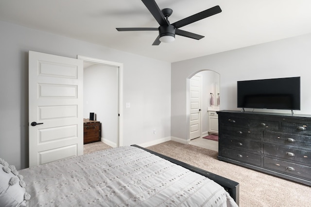 bedroom featuring ensuite bathroom, ceiling fan, and light colored carpet