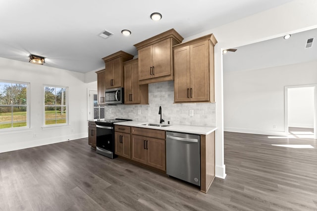 kitchen with dark hardwood / wood-style floors, sink, appliances with stainless steel finishes, and tasteful backsplash