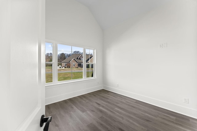 empty room with dark hardwood / wood-style flooring and lofted ceiling