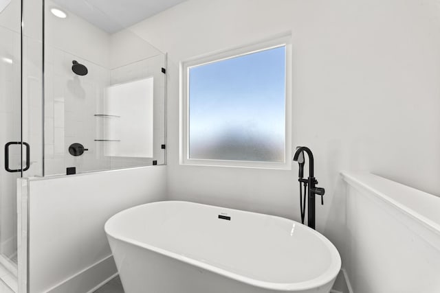 bathroom featuring shower with separate bathtub