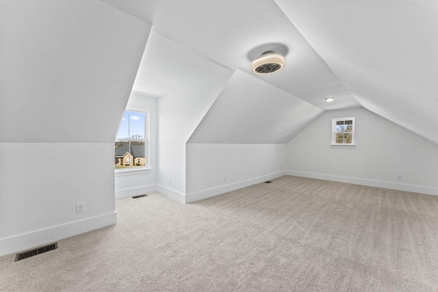 bonus room featuring light colored carpet and vaulted ceiling