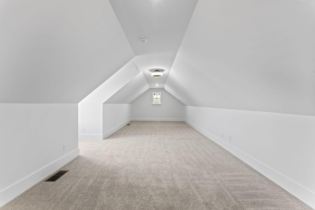 additional living space with lofted ceiling and light carpet