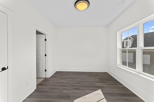 unfurnished room with dark hardwood / wood-style flooring