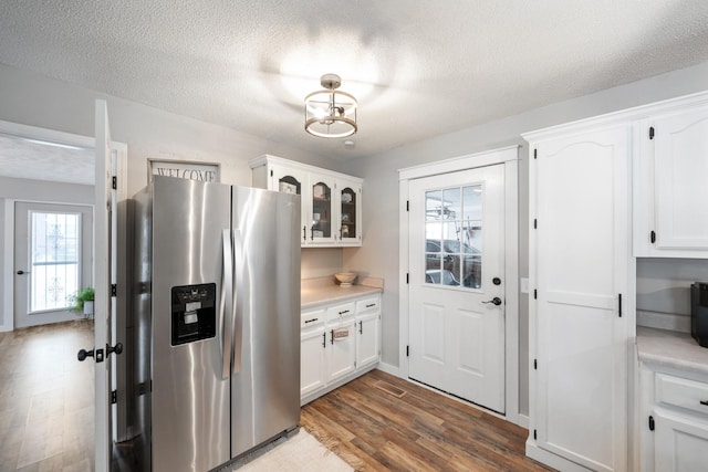 kitchen featuring white cabinets, stainless steel fridge with ice dispenser, a textured ceiling, and hardwood / wood-style floors