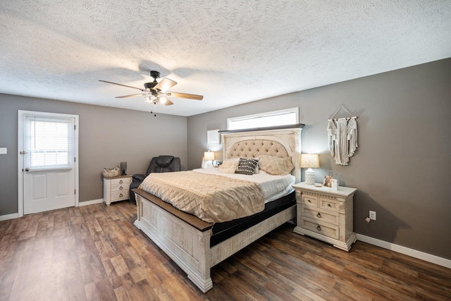 bedroom with a textured ceiling, ceiling fan, and dark wood-type flooring