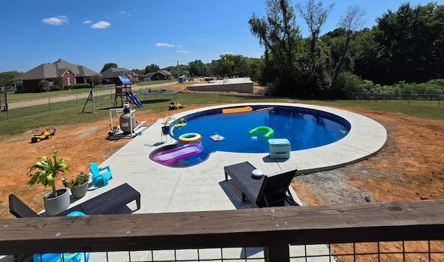 view of swimming pool with a patio and a playground