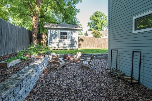 view of yard with a storage shed and an outdoor fire pit