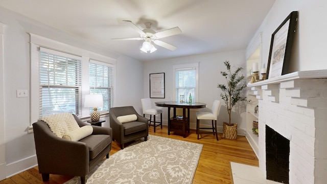 living area with ceiling fan, a healthy amount of sunlight, and light wood-type flooring