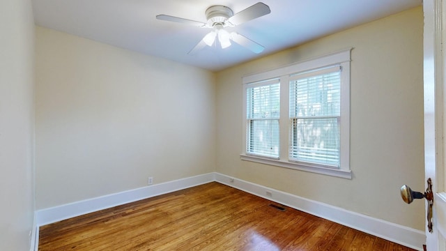 empty room with hardwood / wood-style floors and ceiling fan