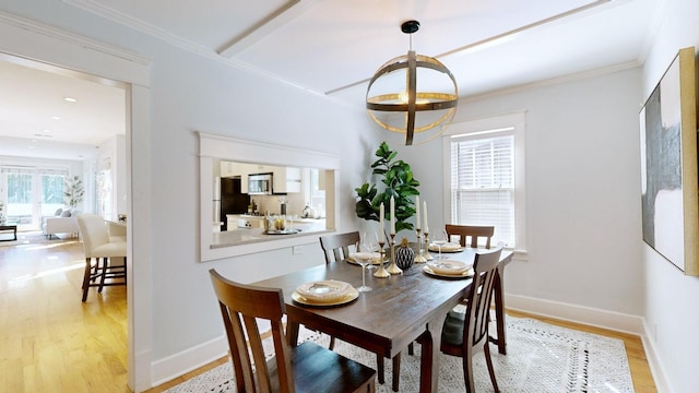 dining room featuring light hardwood / wood-style floors, crown molding, and a wealth of natural light