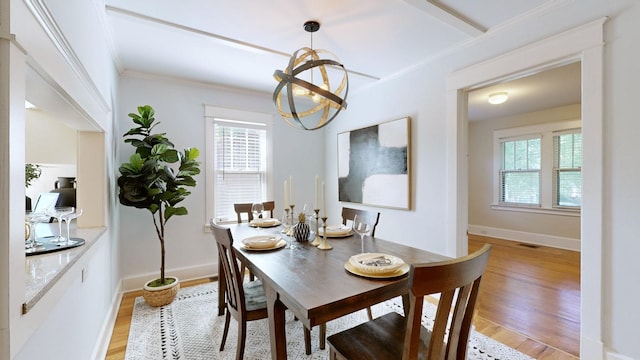 dining room featuring ornamental molding, light hardwood / wood-style flooring, and a chandelier