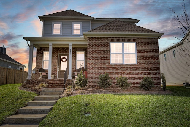 view of front of home with a porch and a lawn