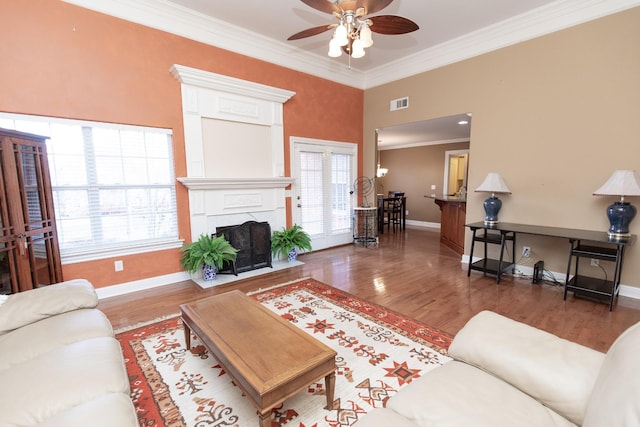 living room with plenty of natural light, ceiling fan, and dark wood-type flooring