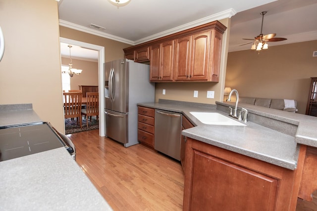 kitchen with sink, light hardwood / wood-style floors, appliances with stainless steel finishes, ceiling fan with notable chandelier, and ornamental molding