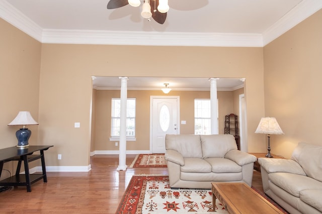 living room featuring ceiling fan, light hardwood / wood-style flooring, crown molding, and decorative columns