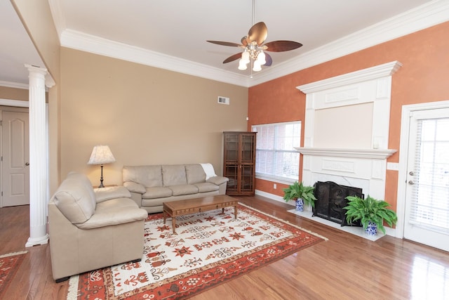 living room featuring hardwood / wood-style floors, crown molding, and a healthy amount of sunlight