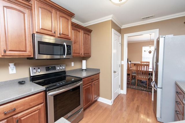 kitchen with a notable chandelier, light hardwood / wood-style floors, ornamental molding, and stainless steel appliances