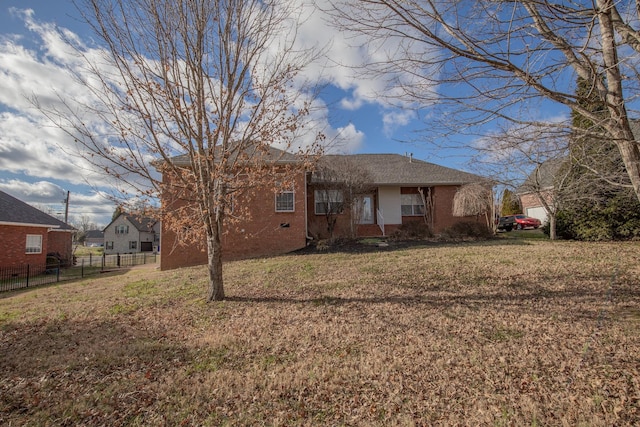 rear view of property featuring a lawn