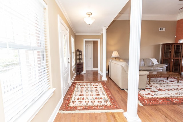 interior space featuring ornate columns, hardwood / wood-style floors, and ornamental molding