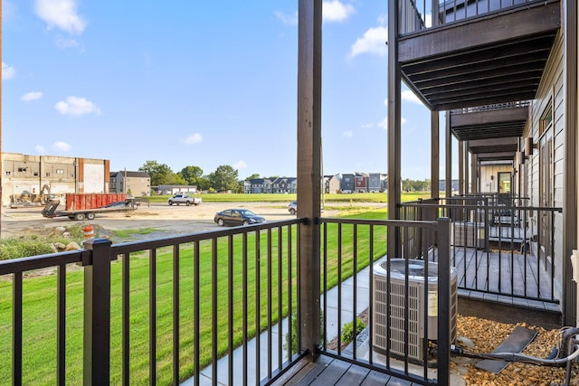 wooden terrace featuring a lawn and cooling unit