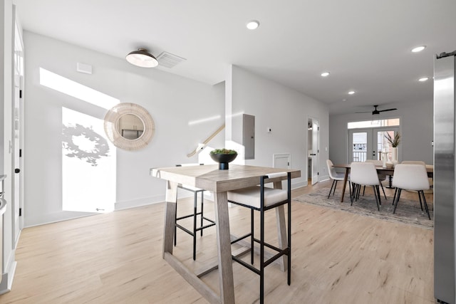 dining area with ceiling fan, light wood-type flooring, and french doors