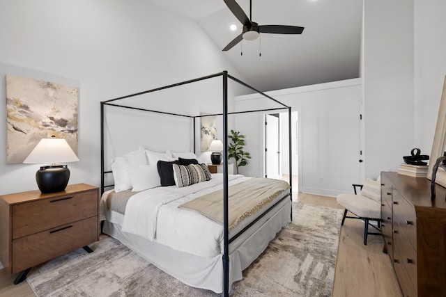 bedroom with ceiling fan, high vaulted ceiling, and light hardwood / wood-style flooring