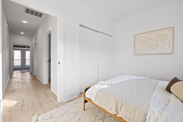 bedroom featuring light hardwood / wood-style floors, french doors, and a closet