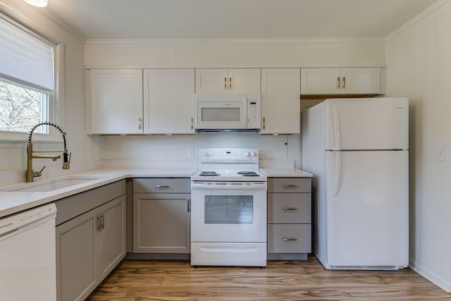 kitchen featuring gray cabinetry, light wood-type flooring, white appliances, and sink