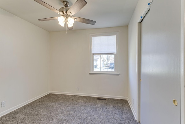 carpeted spare room with ceiling fan