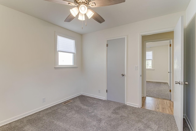 unfurnished bedroom featuring ceiling fan, carpet floors, and multiple windows