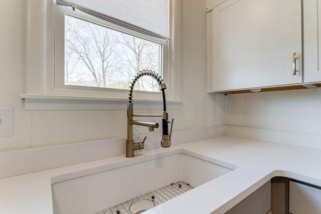 room details featuring white cabinetry and sink