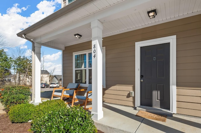 view of exterior entry featuring covered porch