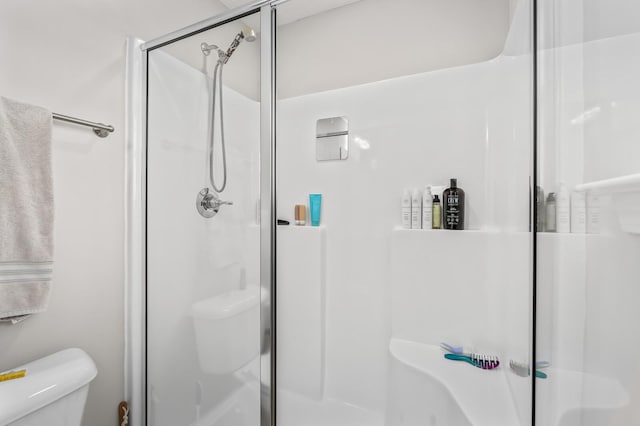 bathroom featuring toilet and an enclosed shower