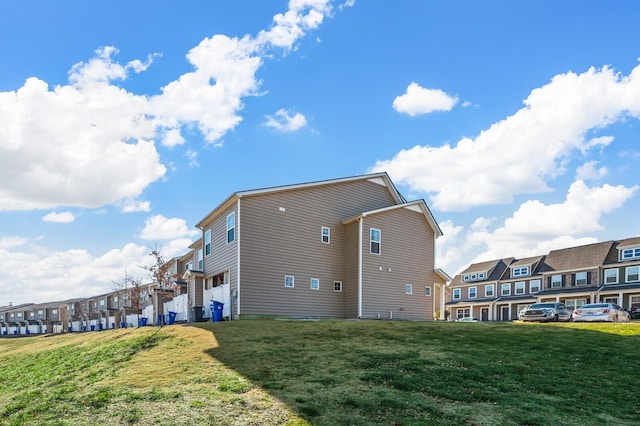 rear view of property featuring a lawn