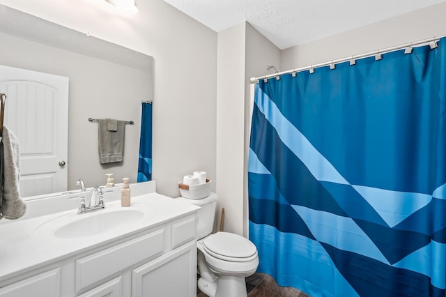 bathroom featuring toilet, vanity, a shower with shower curtain, and a textured ceiling