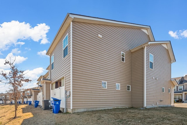 view of property exterior featuring central AC unit and a yard