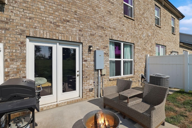 view of patio / terrace with area for grilling, french doors, a fire pit, and central AC