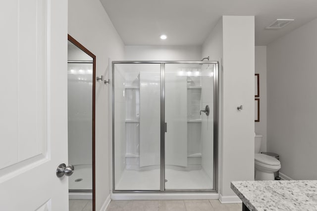 bathroom featuring tile patterned flooring, vanity, toilet, and an enclosed shower